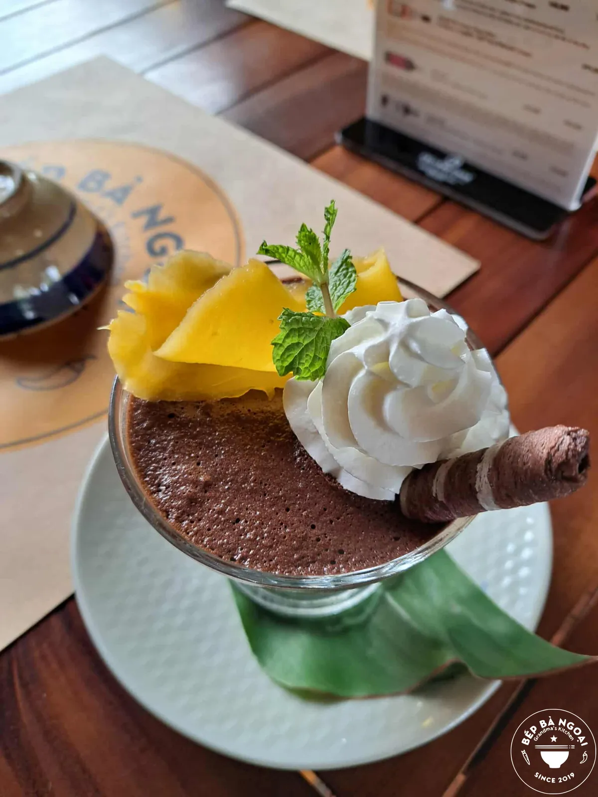 Homemade chocolate mousse topped with mango and whipped cream