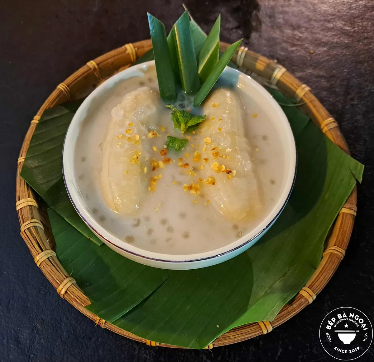 Banana with coconut milk in a bowl on a banana leaf