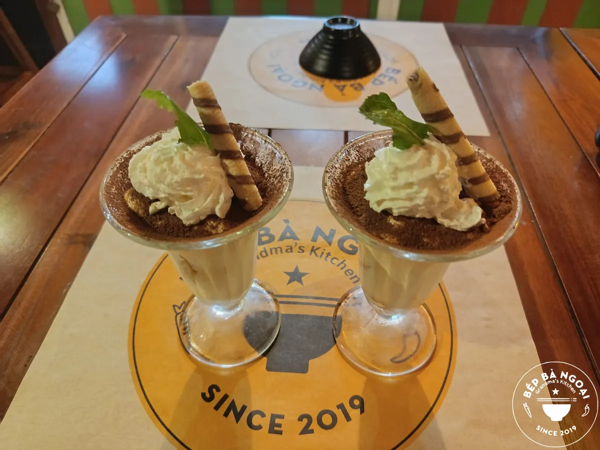 Two glasses of homemade tiramisu with wafer rolls