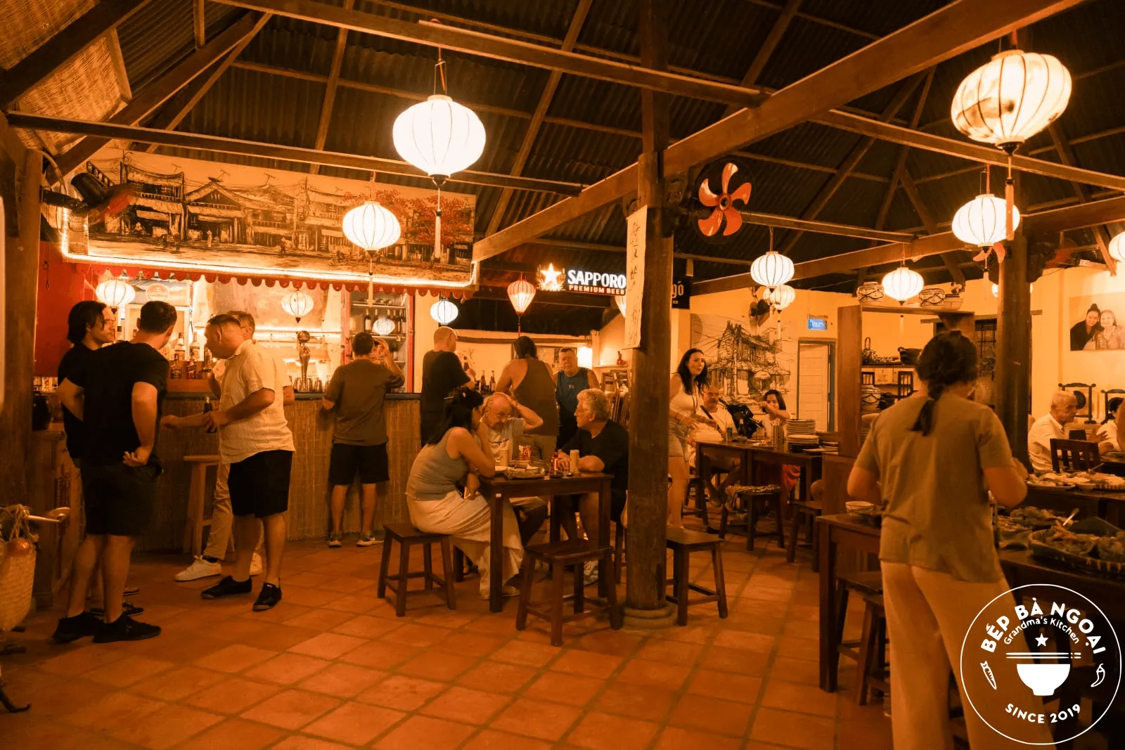 Guests at the bar under paper lanterns