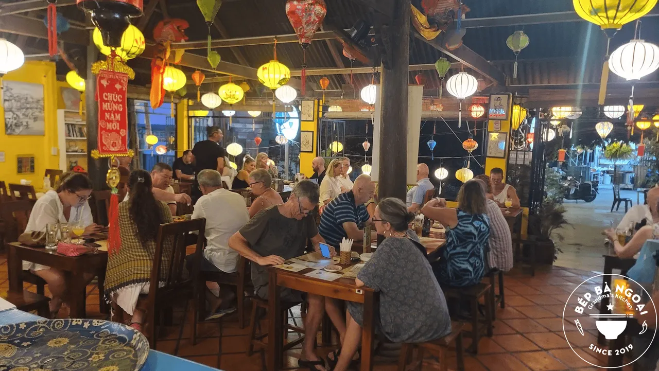 Dining room full of guests under lanterns